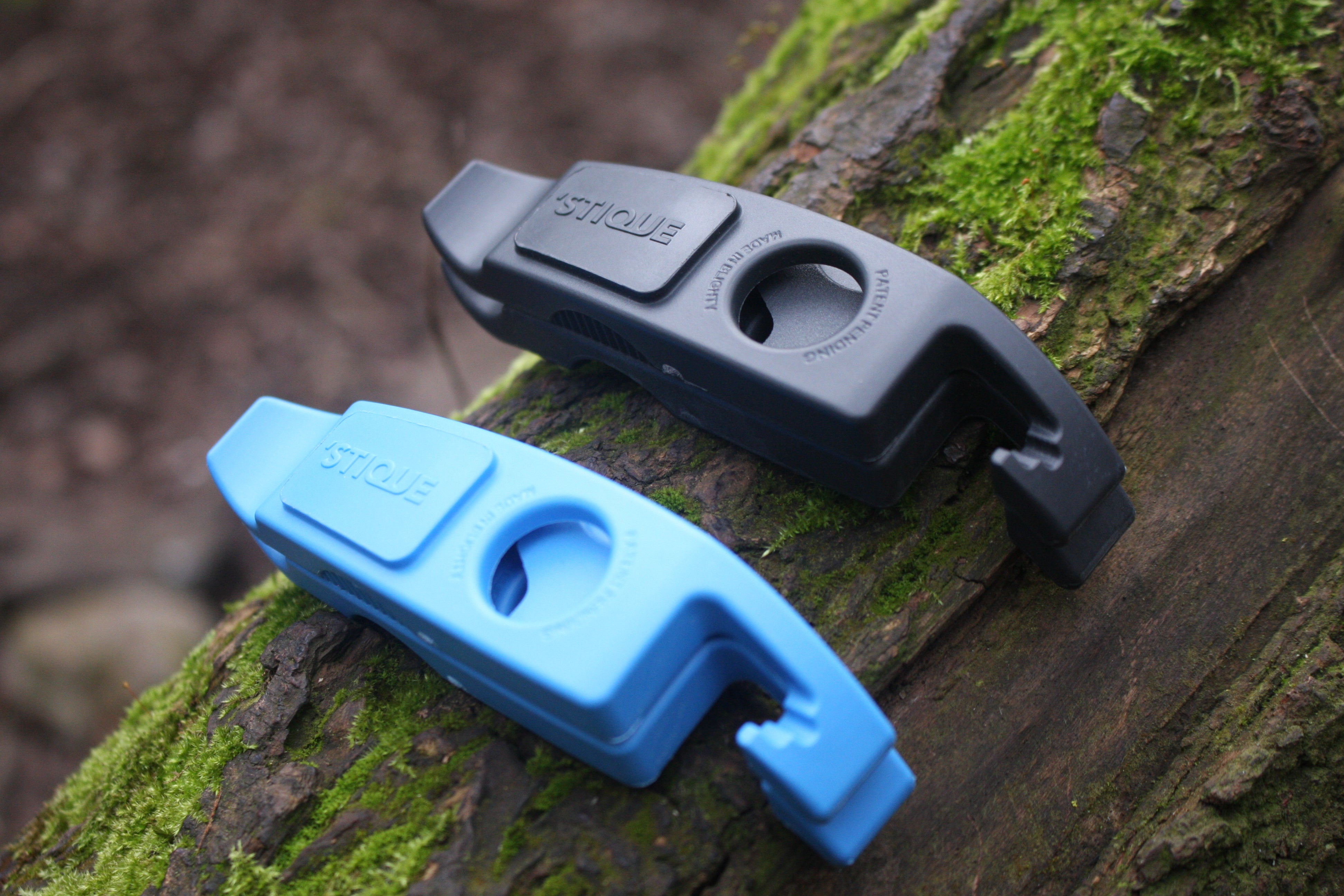Blue and grey ML14 bike tyre levers placed on a moss-covered tree trunk