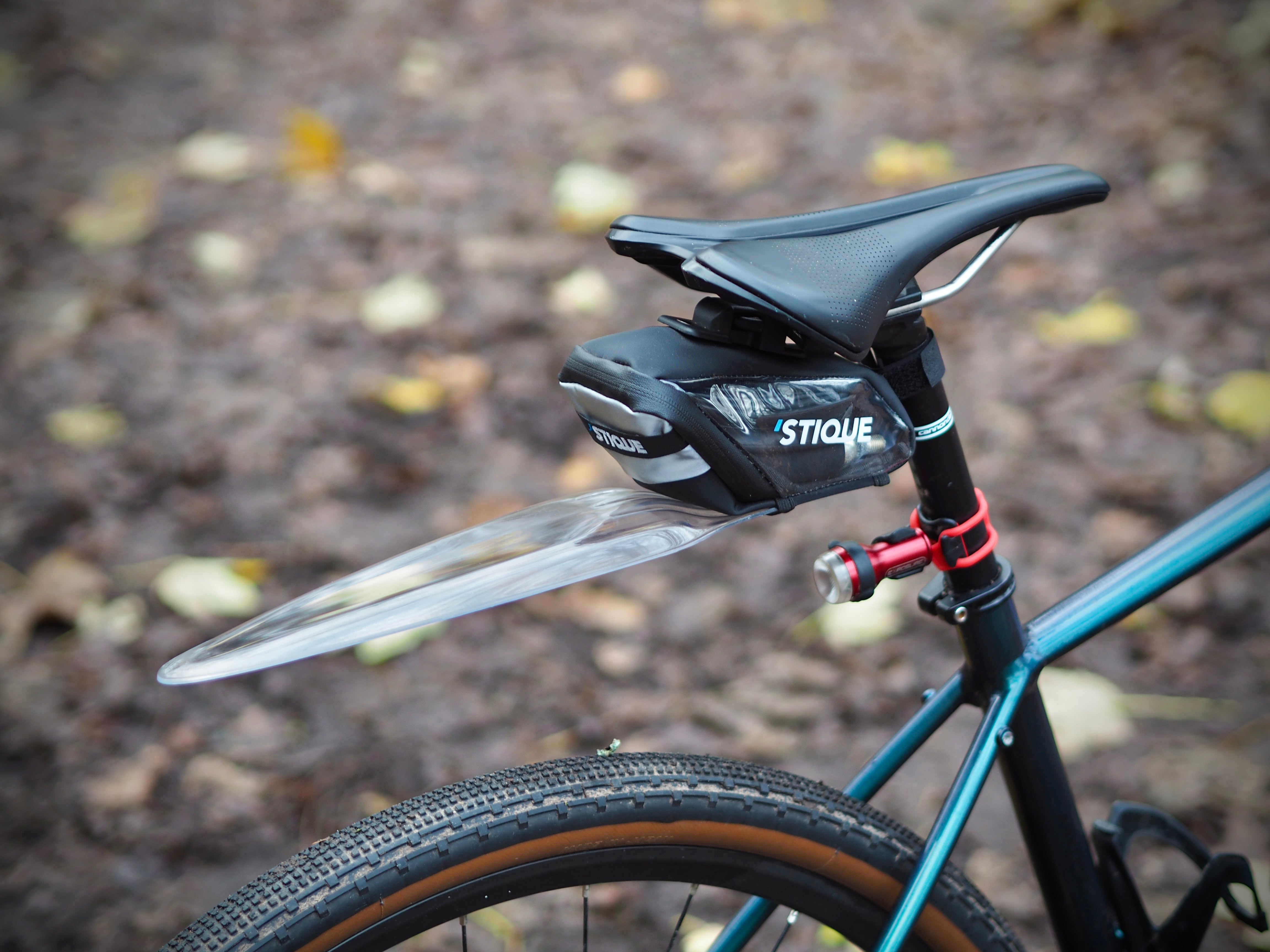 Stique SaddleGuard mounted on a road bike, showing saddle bag and clear mudguard in outdoor setting