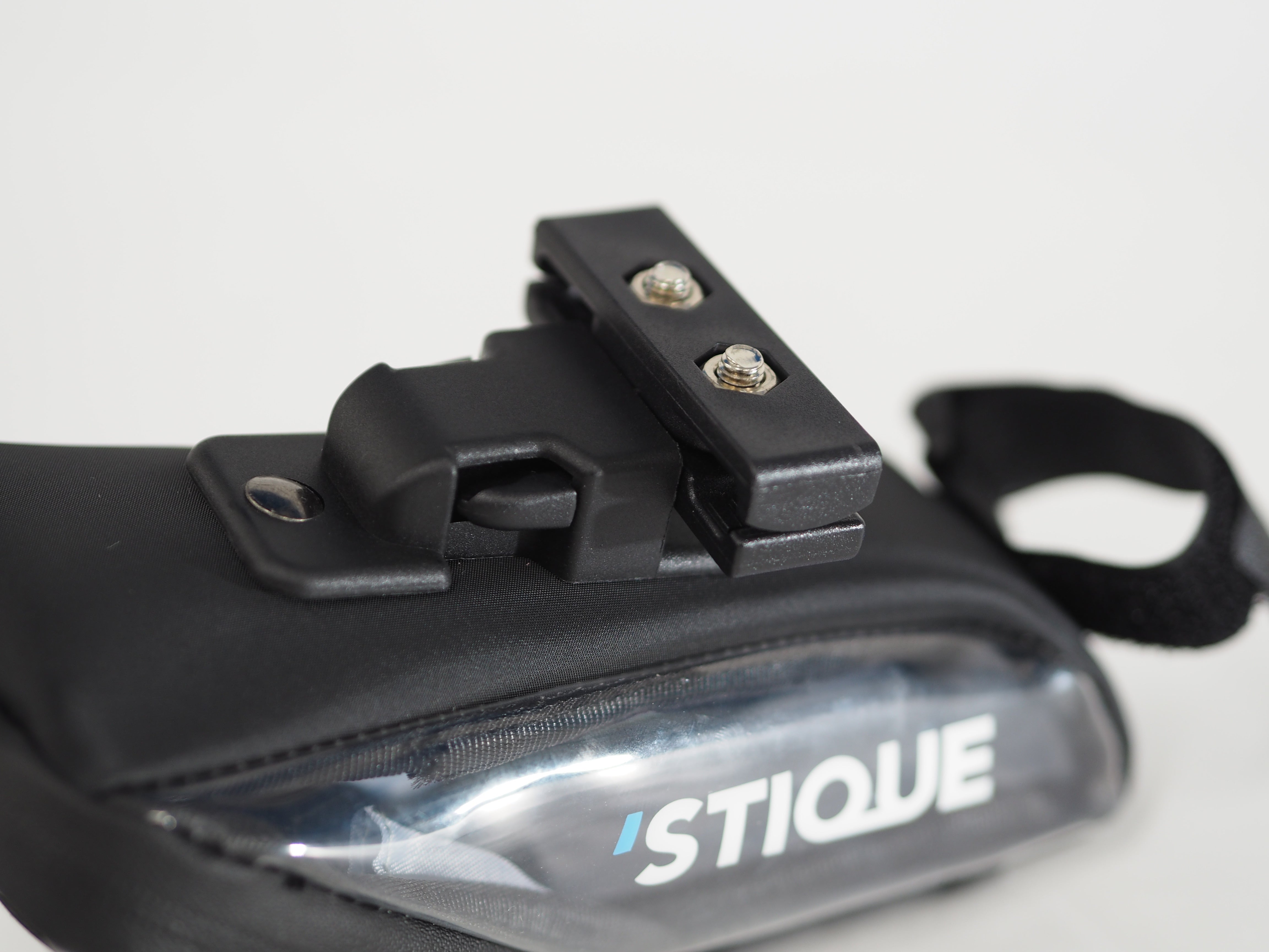 Close-up of Stique SaddleGuard showing the underside mounting clip and transparent side panel with Stique logo